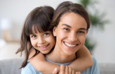 Mother and daughter with healthy smiles after preventive dentistry